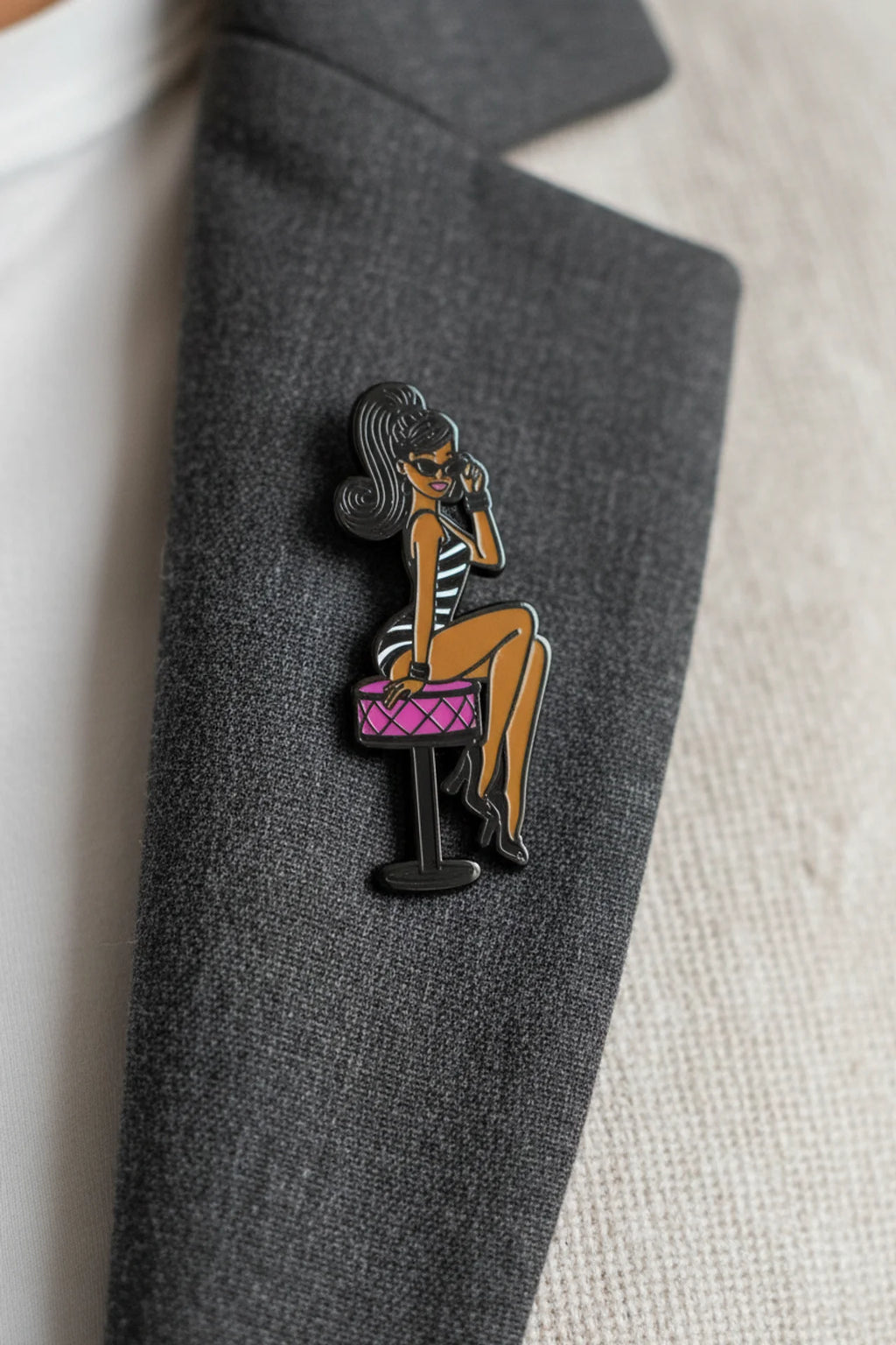 Shop our 1-inch minimalist Black doll pin with sunglasses. Premium enamel lapel pin featuring a rubber clutch. Elevate your everyday style today.
