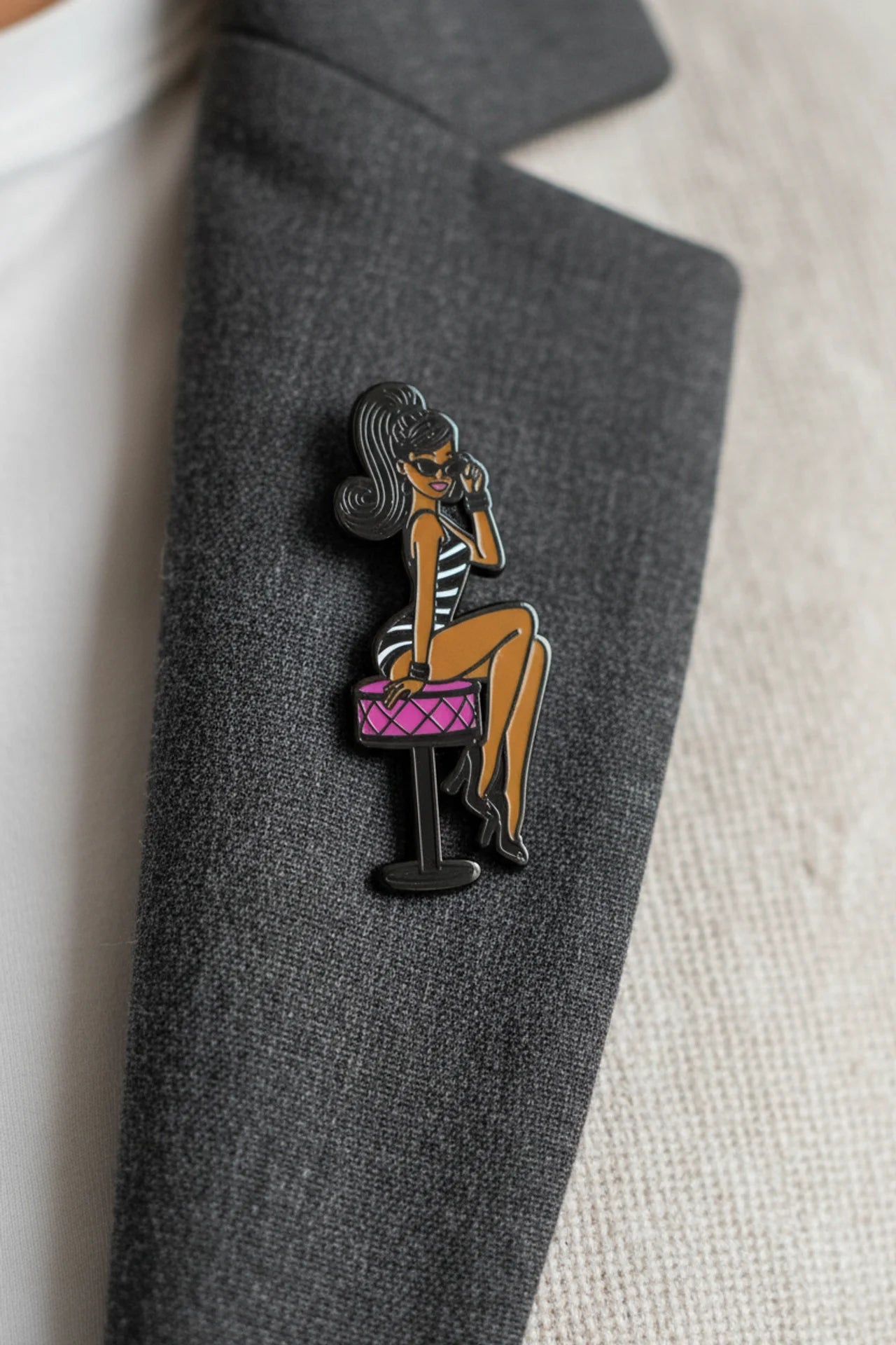 Shop our 1-inch minimalist Black doll pin with sunglasses. Premium enamel lapel pin featuring a rubber clutch. Elevate your everyday style today.